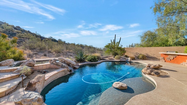 view of swimming pool featuring pool water feature, exterior bar, and a patio area