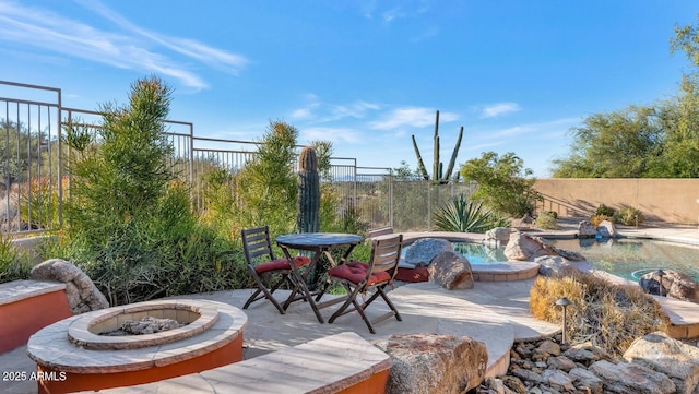 view of patio with a fenced in pool and an outdoor fire pit