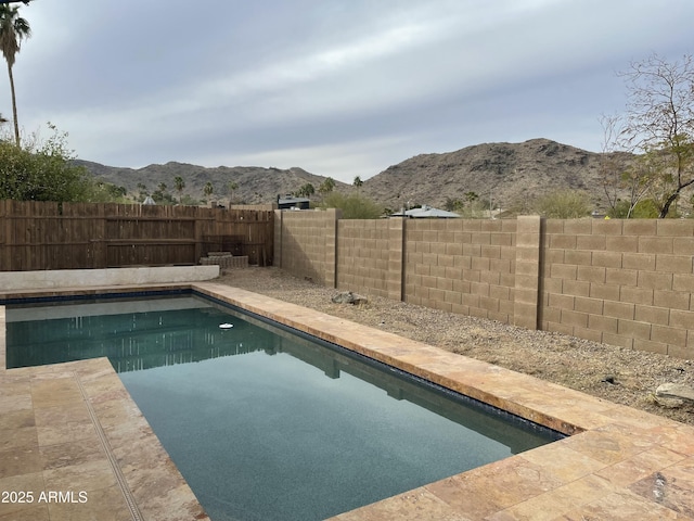 view of swimming pool featuring a fenced in pool, a fenced backyard, and a mountain view