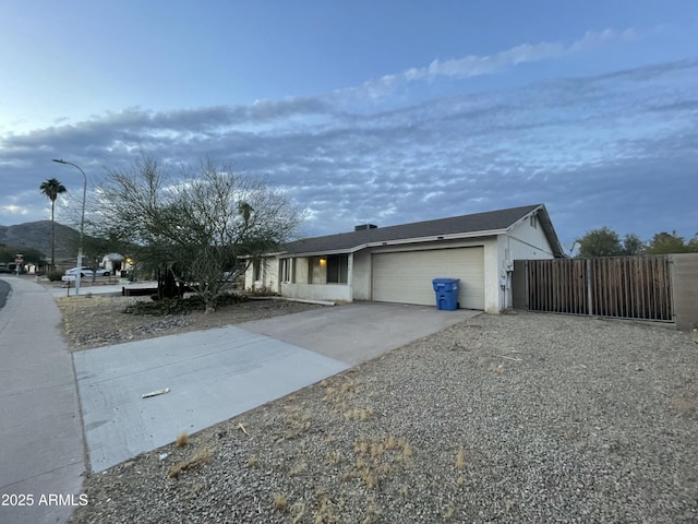 single story home with a garage, driveway, fence, and a gate