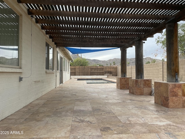 view of patio featuring a fenced backyard, a mountain view, and a pergola