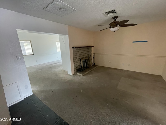 unfurnished living room featuring a brick fireplace, visible vents, and unfinished concrete flooring