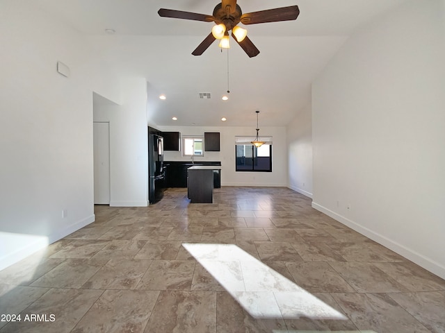 unfurnished living room featuring vaulted ceiling and ceiling fan