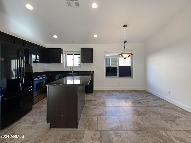 kitchen featuring hanging light fixtures, black fridge, stainless steel stove, sink, and a center island