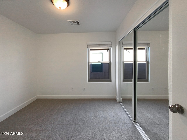 unfurnished bedroom with a closet and carpet flooring