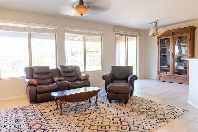 living room with light tile patterned floors and ceiling fan with notable chandelier