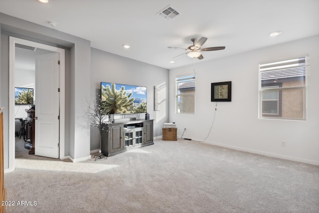 unfurnished living room featuring ceiling fan and light colored carpet