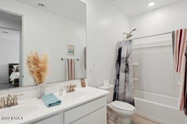 full bathroom featuring shower / bath combination with curtain, toilet, and vanity