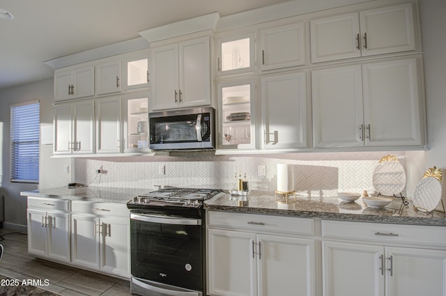 kitchen with stone counters, tasteful backsplash, white cabinetry, and stainless steel appliances