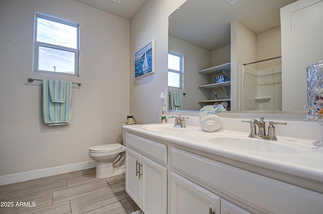 bathroom featuring a healthy amount of sunlight, baseboards, and a sink