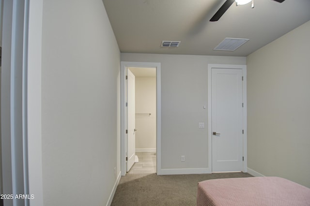 bedroom with light carpet, ceiling fan, visible vents, and baseboards