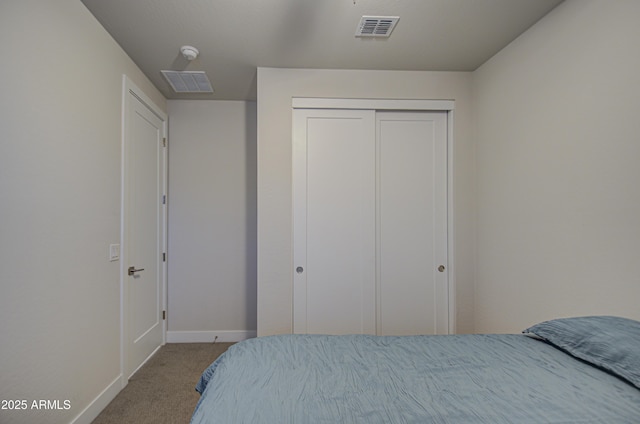 bedroom featuring baseboards, visible vents, a closet, and light colored carpet