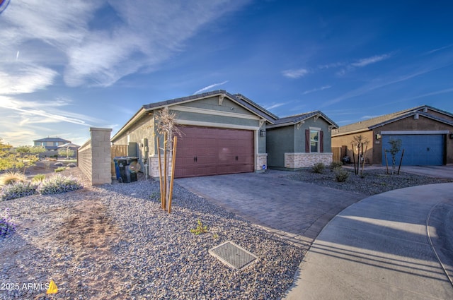 ranch-style home featuring decorative driveway, an attached garage, and stucco siding