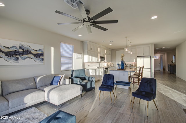 living room with ceiling fan, wood finish floors, visible vents, and recessed lighting