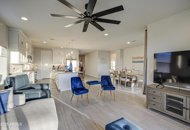 living room with wood tiled floor, visible vents, a ceiling fan, and recessed lighting