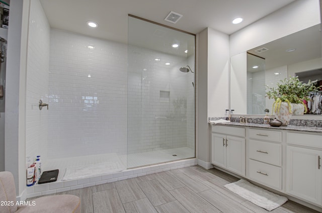 full bath featuring visible vents, vanity, and walk in shower