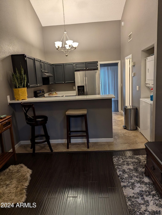 kitchen with a breakfast bar area, kitchen peninsula, and stainless steel refrigerator with ice dispenser