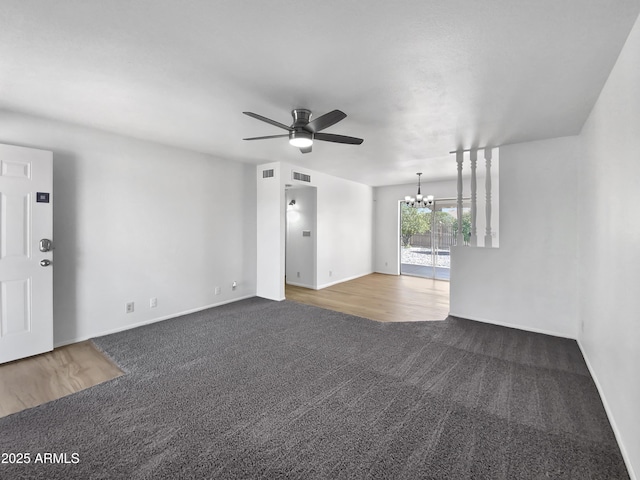 unfurnished living room featuring carpet flooring, ceiling fan with notable chandelier, and visible vents