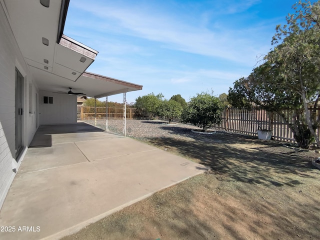 view of yard featuring a patio area, an attached carport, ceiling fan, and fence