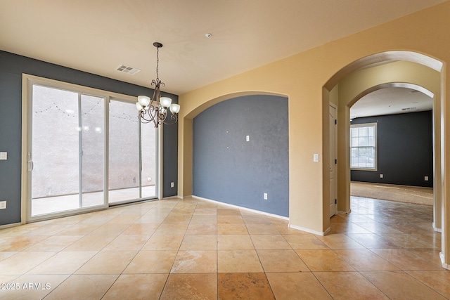 unfurnished dining area with a notable chandelier and light tile patterned flooring