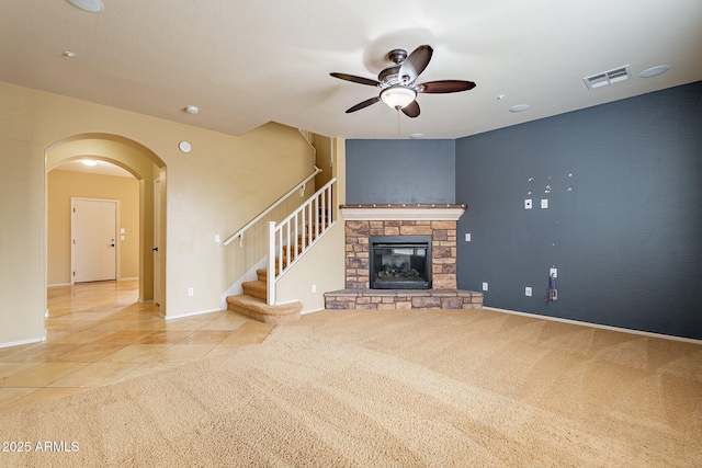 unfurnished living room featuring tile patterned floors, ceiling fan, and a fireplace