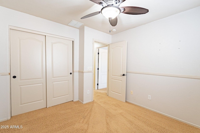 unfurnished bedroom with ceiling fan, a closet, and light carpet