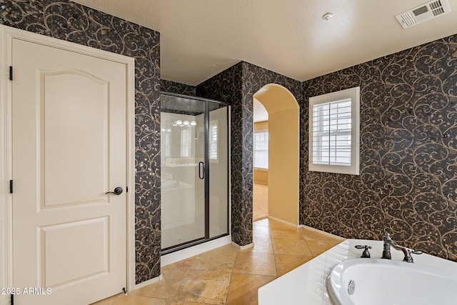 bathroom with plus walk in shower and a textured ceiling