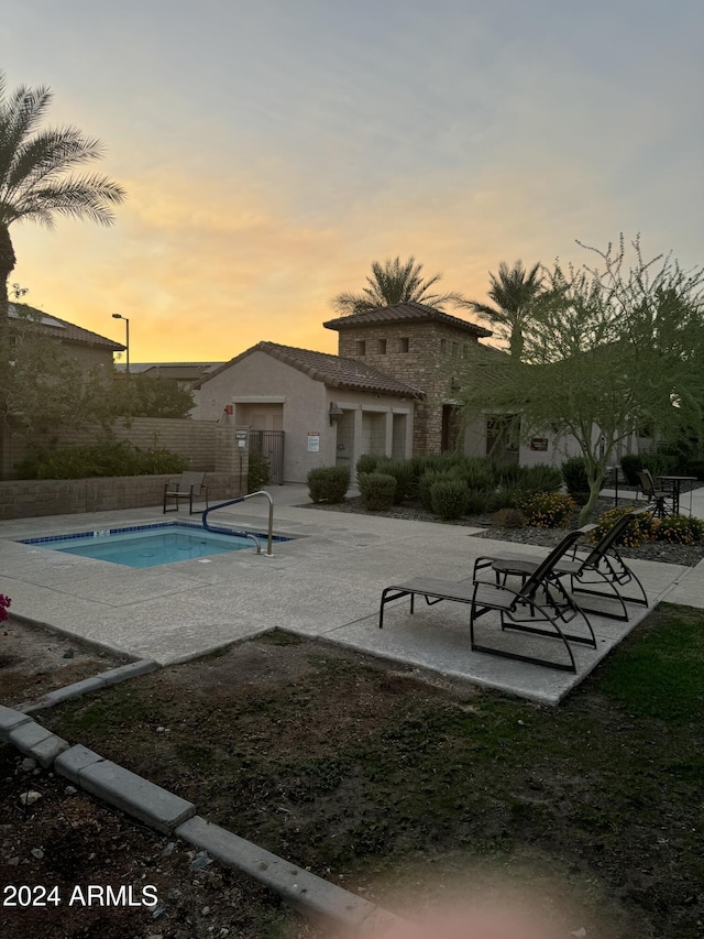 pool at dusk with a patio area