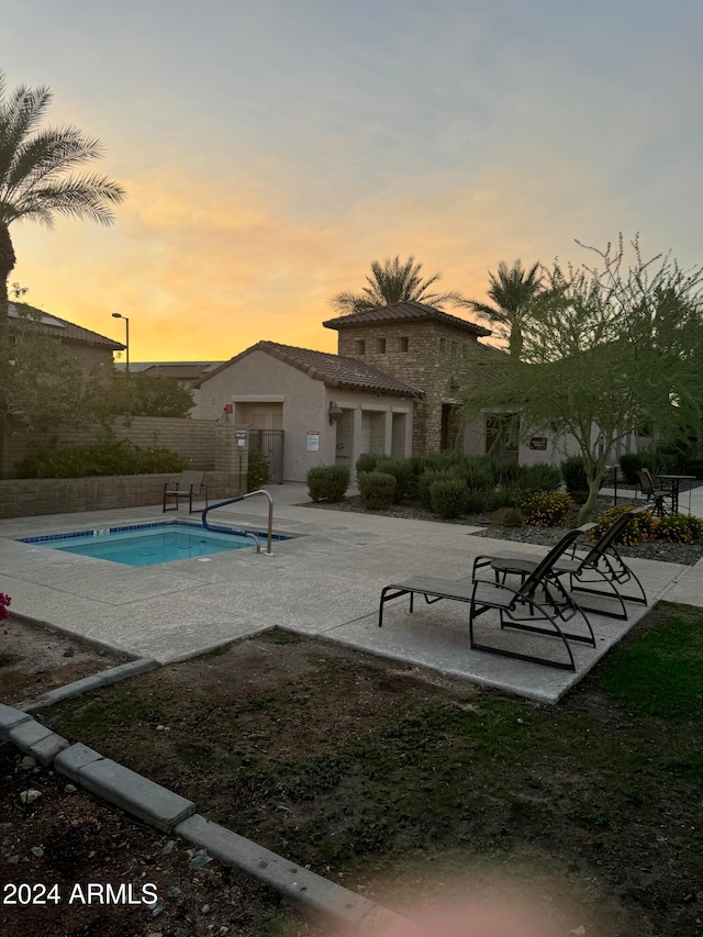 pool at dusk with a patio area