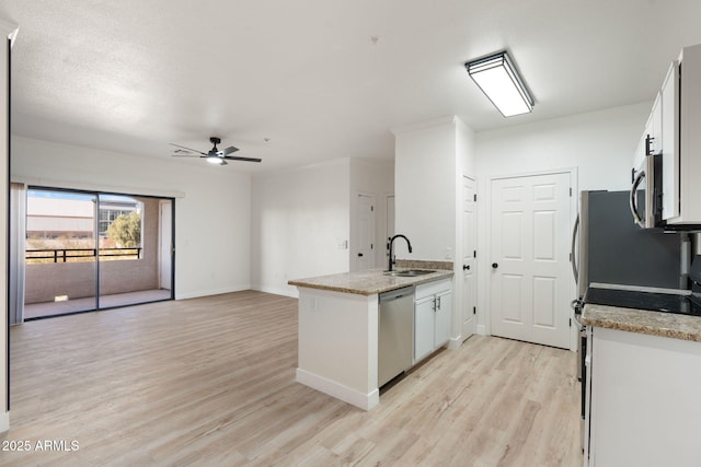 kitchen with sink, light hardwood / wood-style flooring, white cabinets, and appliances with stainless steel finishes