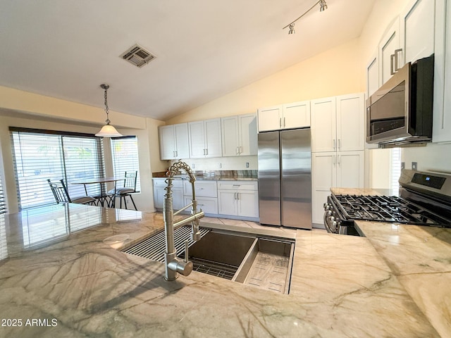 17371 N 86th Ave, Peoria, AZ 85382 - kitchen with stainless steel appliances, lofted ceiling, hanging light fixtures, white cabinetry, and light stone counters
