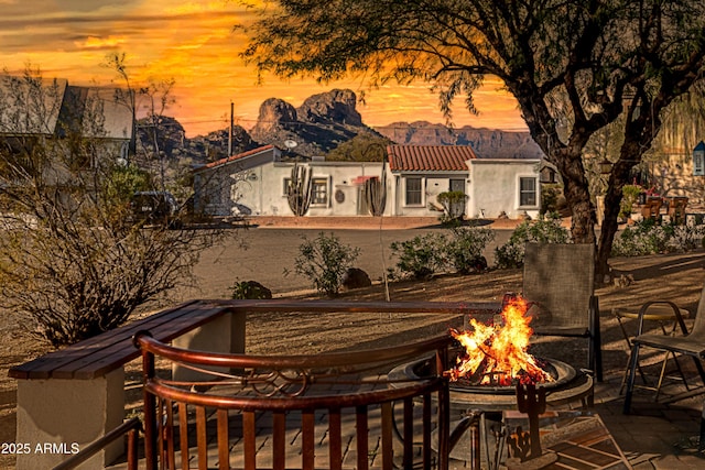 back house at dusk featuring an outdoor fire pit and a mountain view