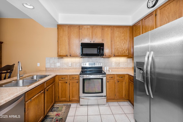 kitchen with backsplash, sink, stainless steel appliances, and light tile patterned flooring