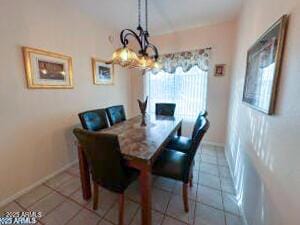 tiled dining space featuring a chandelier