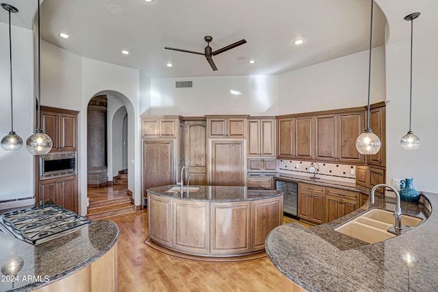 kitchen featuring ceiling fan, sink, light hardwood / wood-style flooring, and high vaulted ceiling