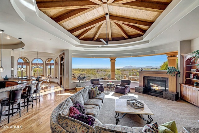 living room with a high end fireplace, vaulted ceiling with beams, light hardwood / wood-style floors, and wood ceiling