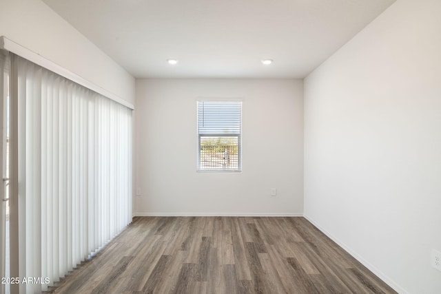 unfurnished room featuring recessed lighting, baseboards, and wood finished floors