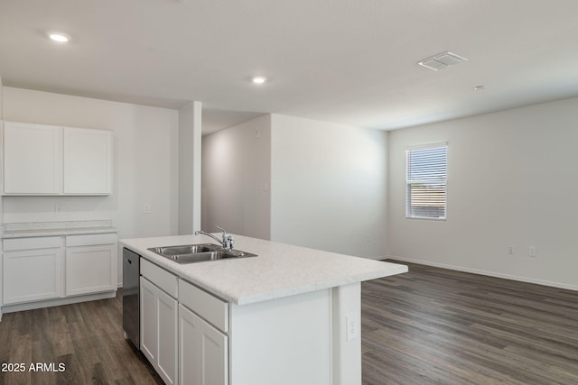 kitchen with a sink, light countertops, an island with sink, dark wood-type flooring, and stainless steel dishwasher