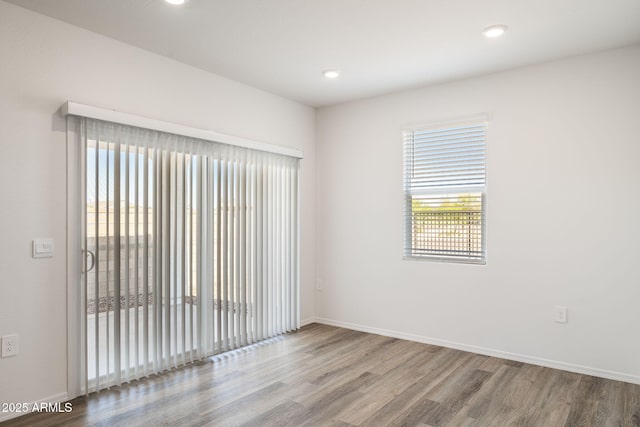 unfurnished room featuring baseboards, recessed lighting, and wood finished floors