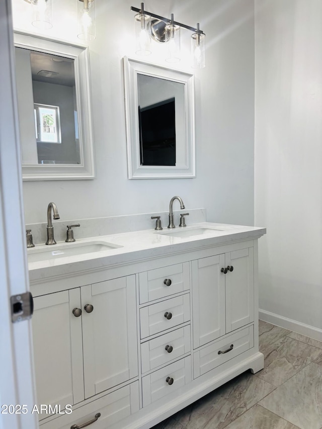 full bathroom featuring marble finish floor, a sink, and double vanity