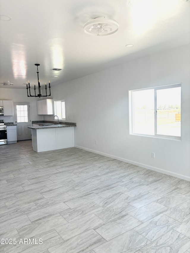 unfurnished living room featuring visible vents, baseboards, an inviting chandelier, and marble finish floor