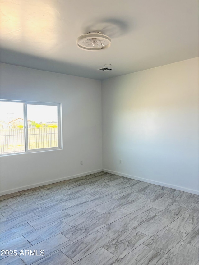 empty room with baseboards and marble finish floor