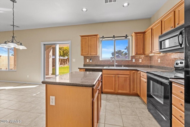 kitchen with sink, a kitchen island, tasteful backsplash, light tile patterned flooring, and black appliances