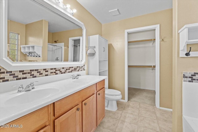 bathroom with a shower with door, vanity, tile patterned flooring, and toilet