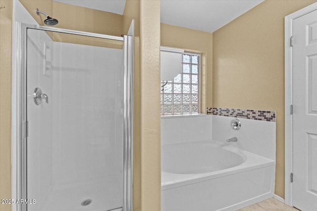 bathroom featuring tile patterned flooring and shower with separate bathtub