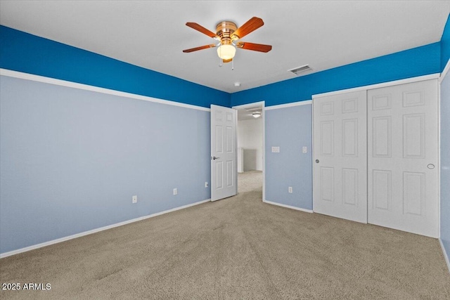 unfurnished bedroom featuring ceiling fan, a closet, and carpet