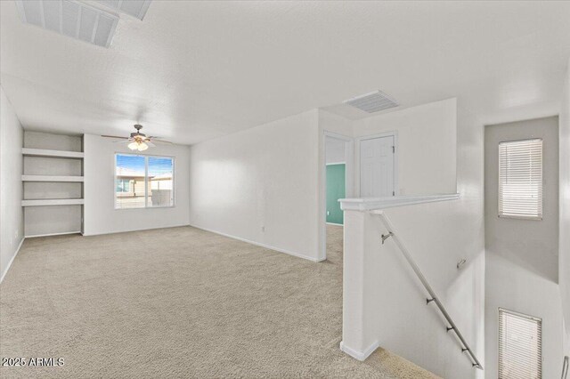 carpeted spare room with ceiling fan