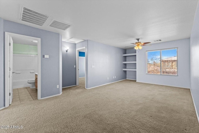 interior space featuring light carpet, connected bathroom, and ceiling fan