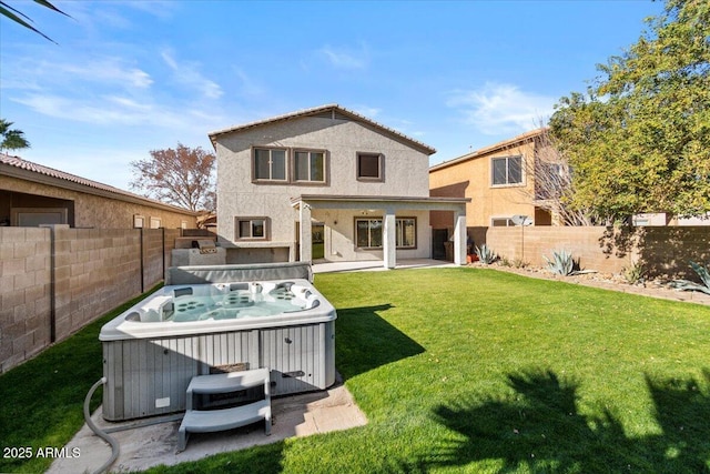 back of property with a hot tub, a patio, and a yard