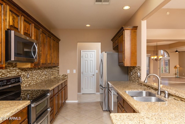 kitchen with decorative backsplash, sink, an inviting chandelier, and appliances with stainless steel finishes